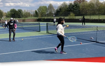 Kids playing on a blue tennis court